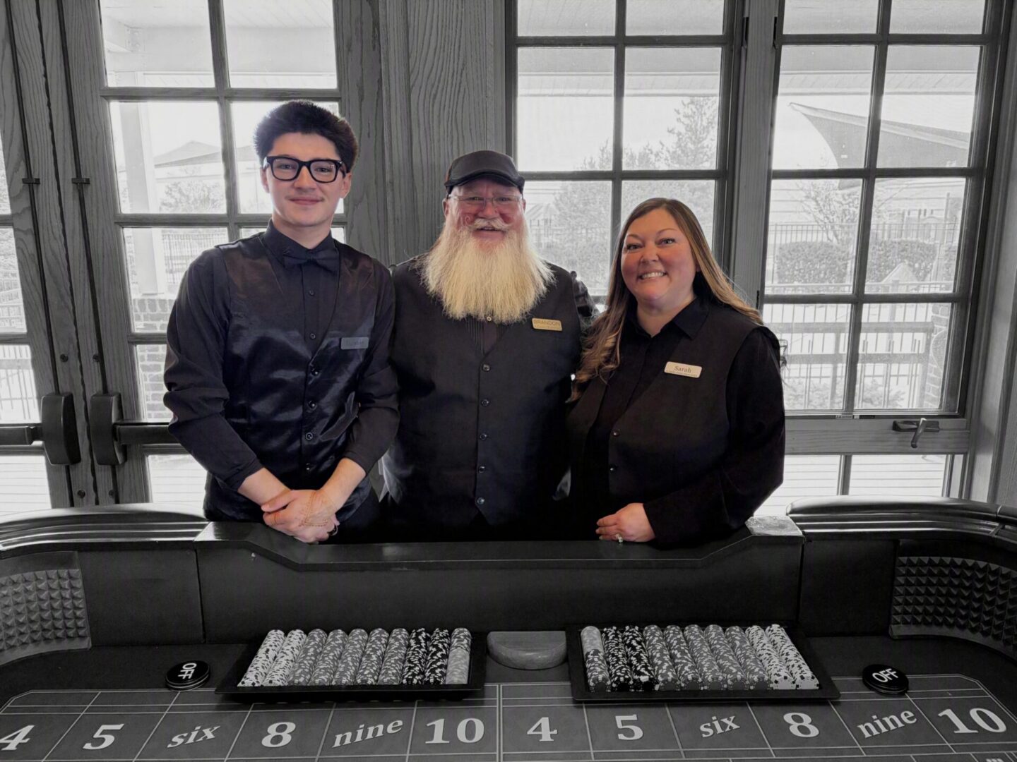 Casino dealers smiling behind gaming table