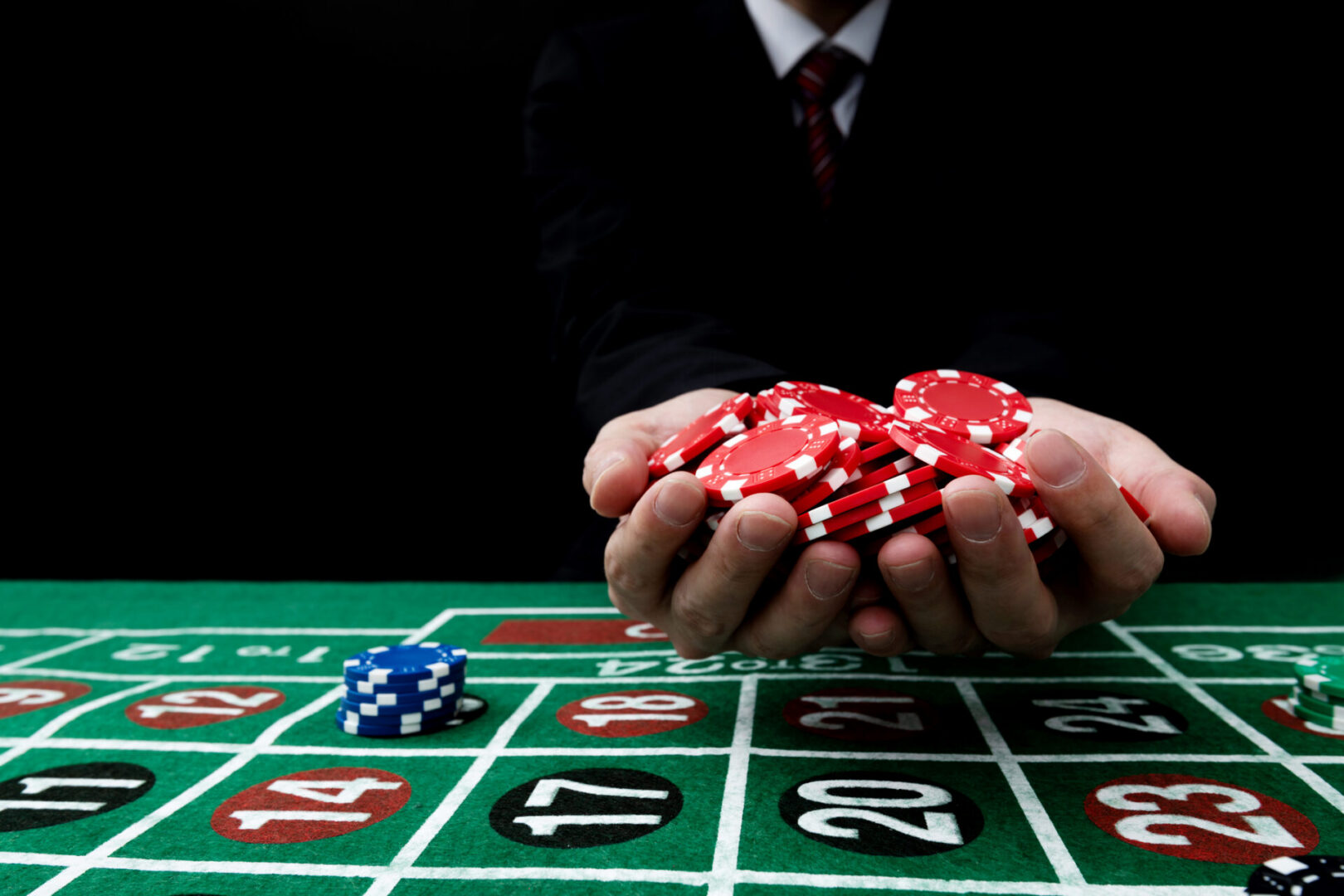 Person collecting chips on roulette layout